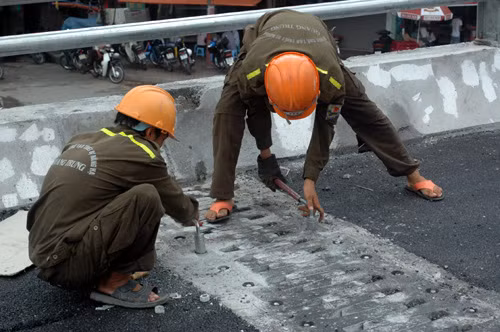 Các công nhân đang khẩn trương hoàn thành các hạng mục tại cây cầu.