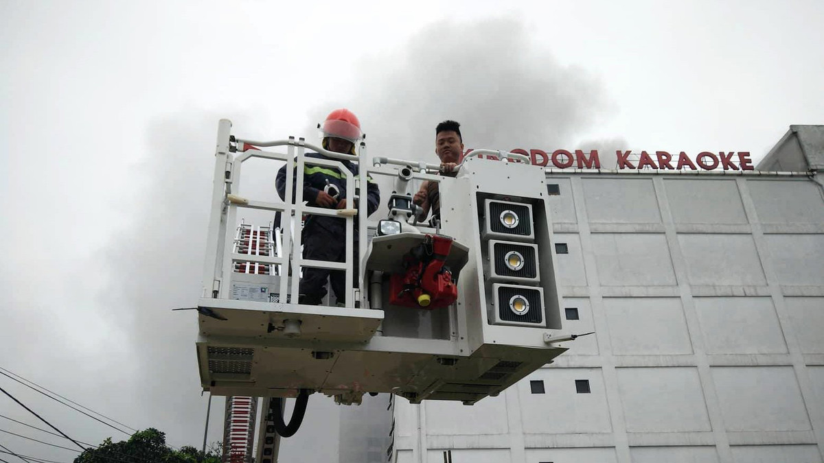 Một nhân viên karaoke được lực lượng cứu hộ dùng thang cứu ra khỏi toà nhà