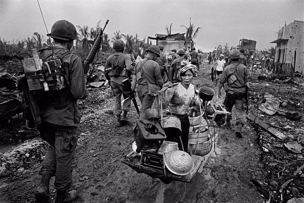 Người phụ nữ tay xách nách mang khi di tản khỏi vùng chiến sự ở Sài Gòn năm 1968. Ảnh: Philip Jones Griffiths/ Magnum.