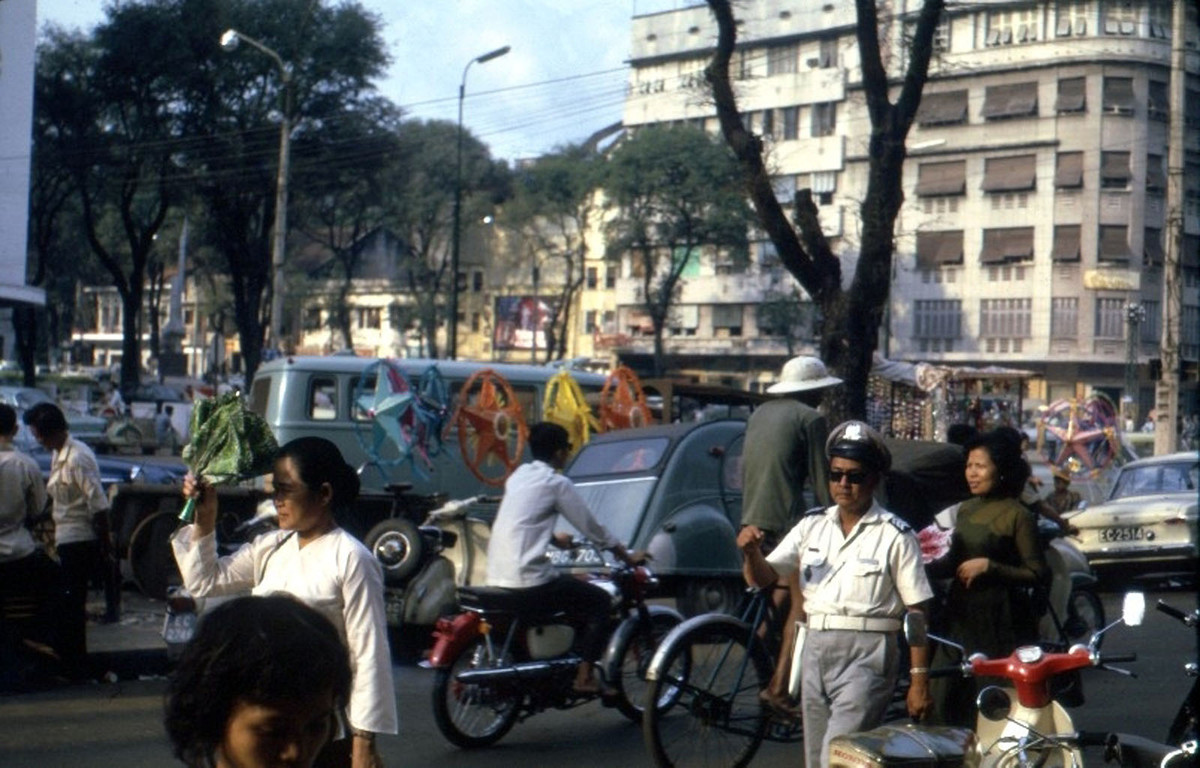 Thương xá Eden trên đại lộ Lê Lợi phía bên kia đường. Trên vỉa hè có những chiếc đèn ông sao được bày bán dịp Giáng sinh. Ảnh: Thomas Southall.
