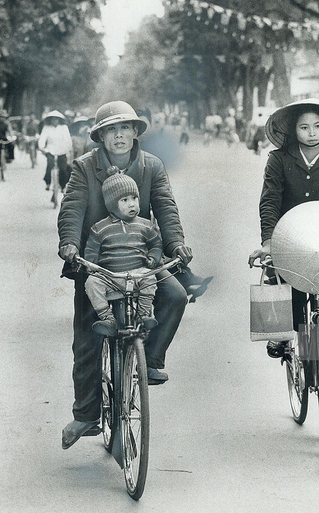 Em bé ngồi trên xe đạp của bố. Vào thập niên 1970, mỗi chiếc xe đạp là cả một gia tài của người Hà Nội. Ảnh tư liệu.