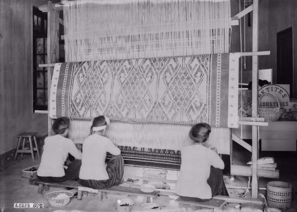 Những người phụ nữ học sản xuất thảm lụa thủ công tại một gian của bảo tàng.