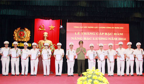 Trung tướng Nguyễn Xuân Tư trao quyết định nâng lương cấp bậc hàm tại buổi lễ công bố và trao các quyết định của lãnh đạo Bộ Công an về việc thăng cấp bậc hàm, nâng bậc lương niên hạn năm 2014 do Tổng cục Xây dựng lực lượng Công an nhân dân tổ chức tại Hà Nội ngày 30/7/2014.