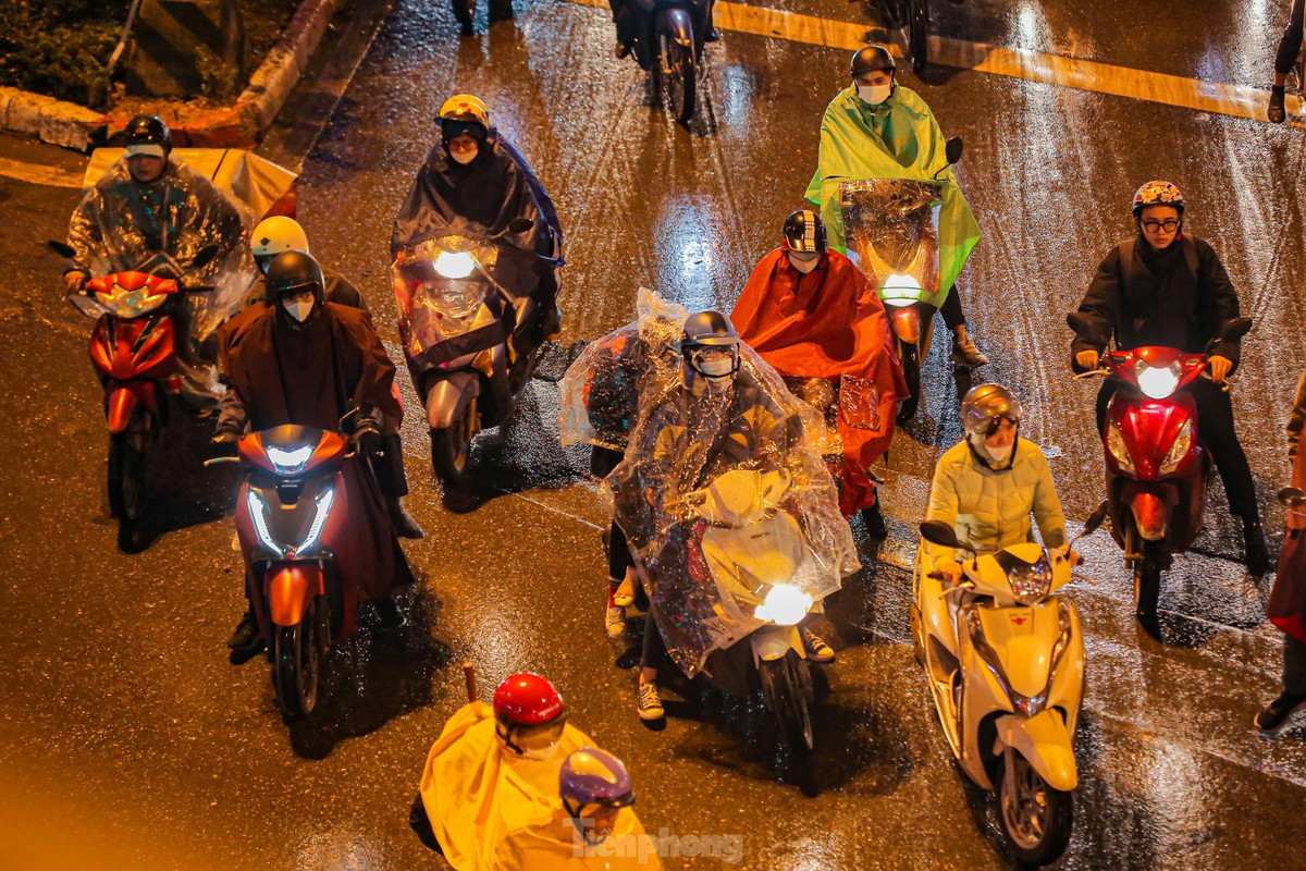 Các phương tiện chờ đèn đỏ trong cơn mưa rét.