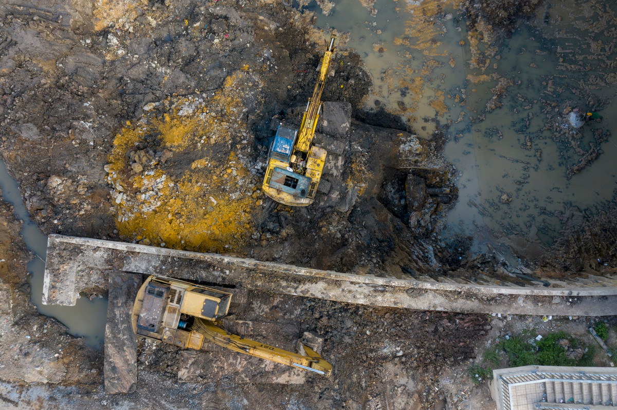 Xe máy xúc nạo vét lòng kênh để khơi thông dòng chảy dưới dạ cầu.