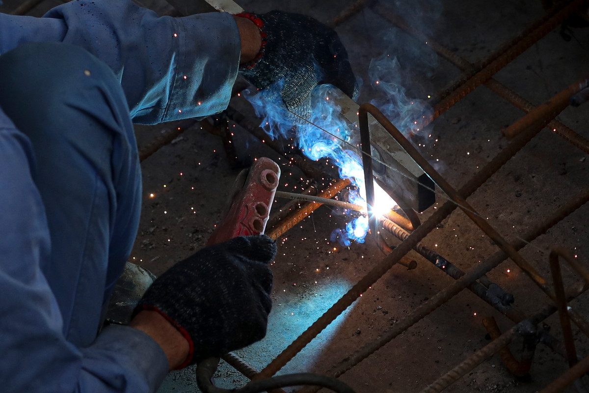 Công nhân hàn khung sắt để chuẩn bị cho công đoạn đổ bê tông lối lên cầu dành cho người đi bộ.