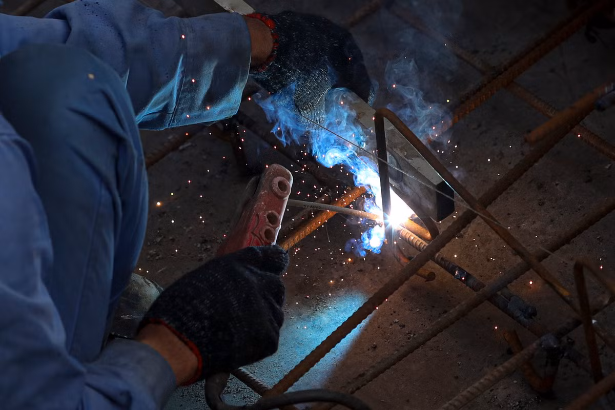 Công nhân hàn khung sắt để chuẩn bị cho công đoạn đổ bê tông lối lên cầu dành cho người đi bộ.