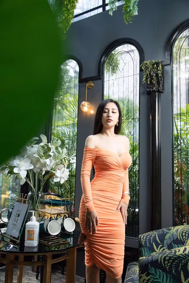 Hoa hậu Việt Nam 2006 diện váy màu cam bó sát, khoe đường cong quyến rũ.