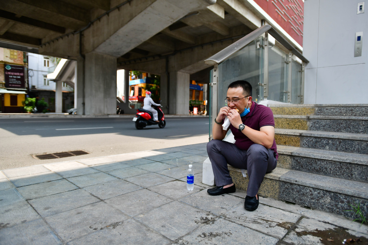 Những ngày hàng quán bán mang về, không chỉ có những công nhân, tài xế xe ôm mà người làm văn phòng cũng tá túc tại vỉa hè để dùng bữa.