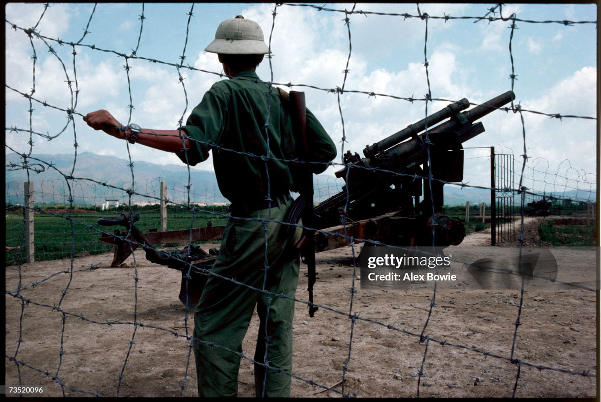 Một người lính đứng bên khẩu lựu pháo quân Pháp từng sử dụng ở cánh đồng Mường Thanh, 7/5/1984.