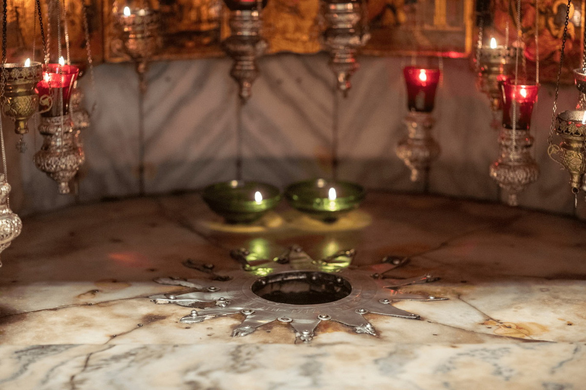 Điểm đản sinh chính xác được đánh dấu dưới một bàn thờ ở thánh đường bởi một ngôi sao 14 mũi nhọn bằng bạc khảm vào bên trong sàn nhà bằng cẩm thạch với các đèn bằng bạc xung quanh. Ảnh: OpenSea.