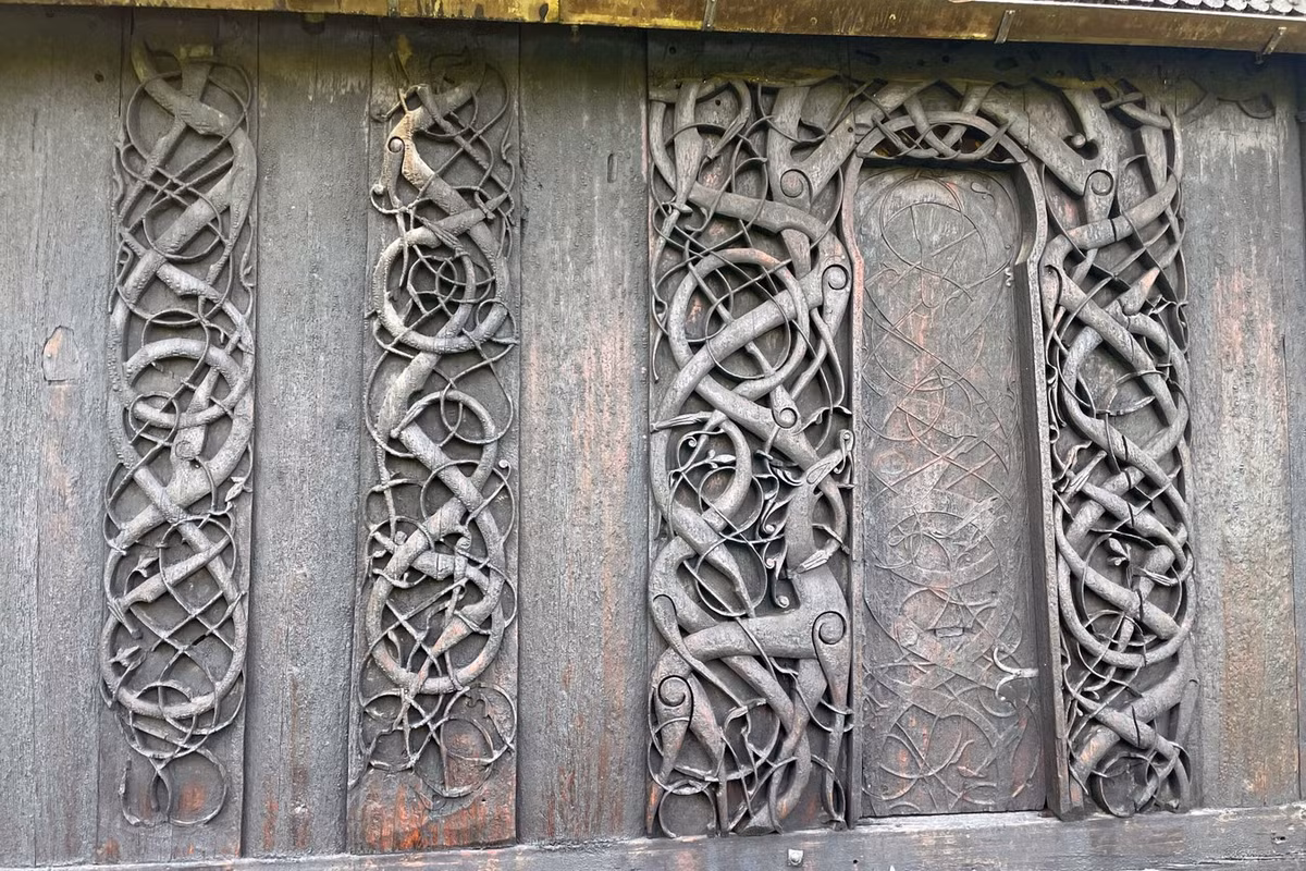 Chi tiết kiến trúc tinh xảo nhất của nhà thờ ván gỗ Urnes là bộ cửa chính với hình tượng một con vật bốn chân và một con rắn đang ngoạm vào cổ nhau. Đây là hình ảnh tượng trưng cho cuộc chiến giữa thiện và ác theo quan niệm của người Viking cổ xưa. Ảnh: Books And Travel.