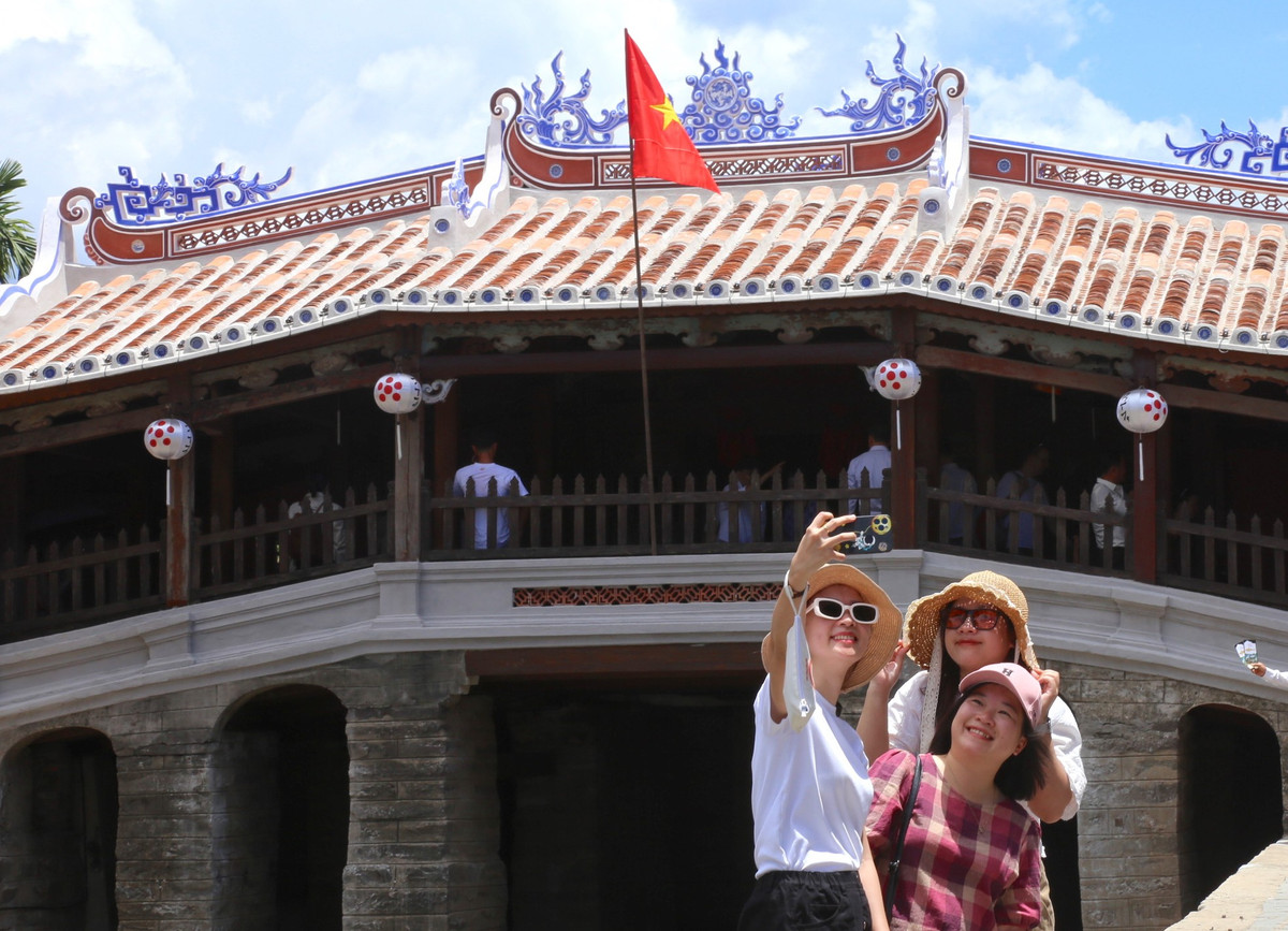 Hình ảnh lá cờ Tổ quốc tung bay trên mái của di tích Chùa Cầu khiến nhiều du khách hào hứng, chụp hình lưu niệm. Ảnh: Hoài Văn.