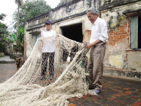 Ông Tiện (phải) bên cheo lưới đánh bắt “hung thần biển cả”.