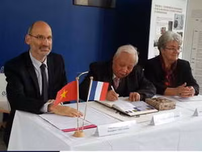 Giáo sư, Viện sĩ Nguyễn Văn Hiệu (giữa) ký Sổ vàng của ĐH Sư phạm Cachan. Ảnh: Vietnam+