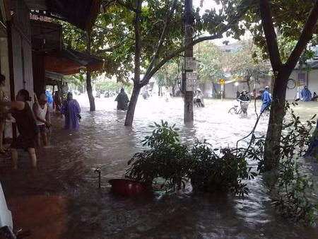 Xe máy không thể hoạt động, người dân buộc phải xắn quần lội bộ. Ảnh: Nông nghiệp VN.