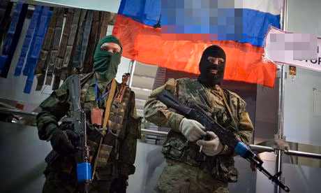 Hai dân quân tự vệ đeo mặt nạ đứng gác ngoài một tòa nhà công quyền ở Lugansk.