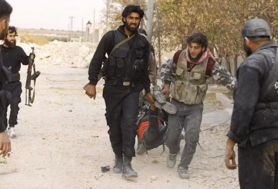 Nhóm phiến quân khiêng thi thể của đồng đội ra khỏi chiến trường.