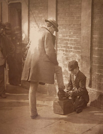 Một cậu bé đánh giày hành nghề trên phố London.