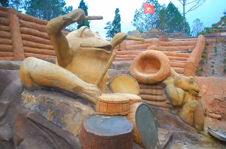 Chủ nhân đường hầm điêu khắc này là anh Trịnh Bá Dũng, một người xuất thân từ ngành kỹ sư hàng hải nhưng mê điêu khắc. Trong hình là tác phẩm ếch đánh trống, thổi kèn vui nhộn.