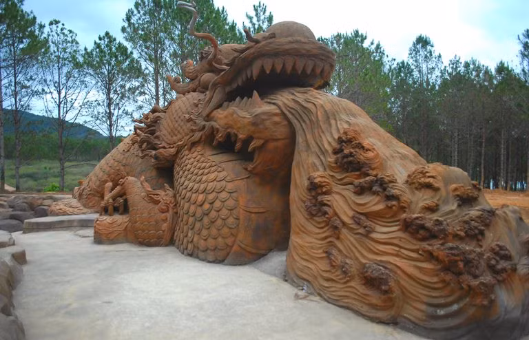 Rồng phun lửa bằng đất trước lối vào đường hầm điêu khắc của "Dũng khùng".