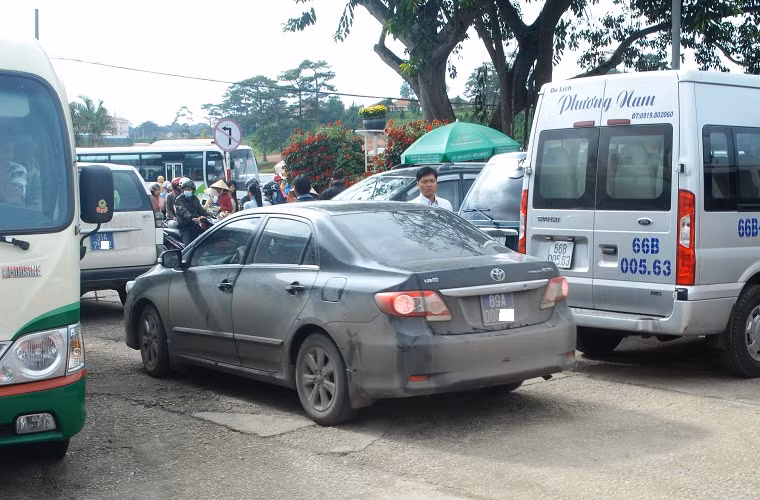 Bấp chấp lệnh cấm sử dung xe công vào việc tư, các xế hộp có biển số xanh (giữa) vẫn nối đuôi nhau vào điểm du lịch Vườn hoa Đà Lạt.