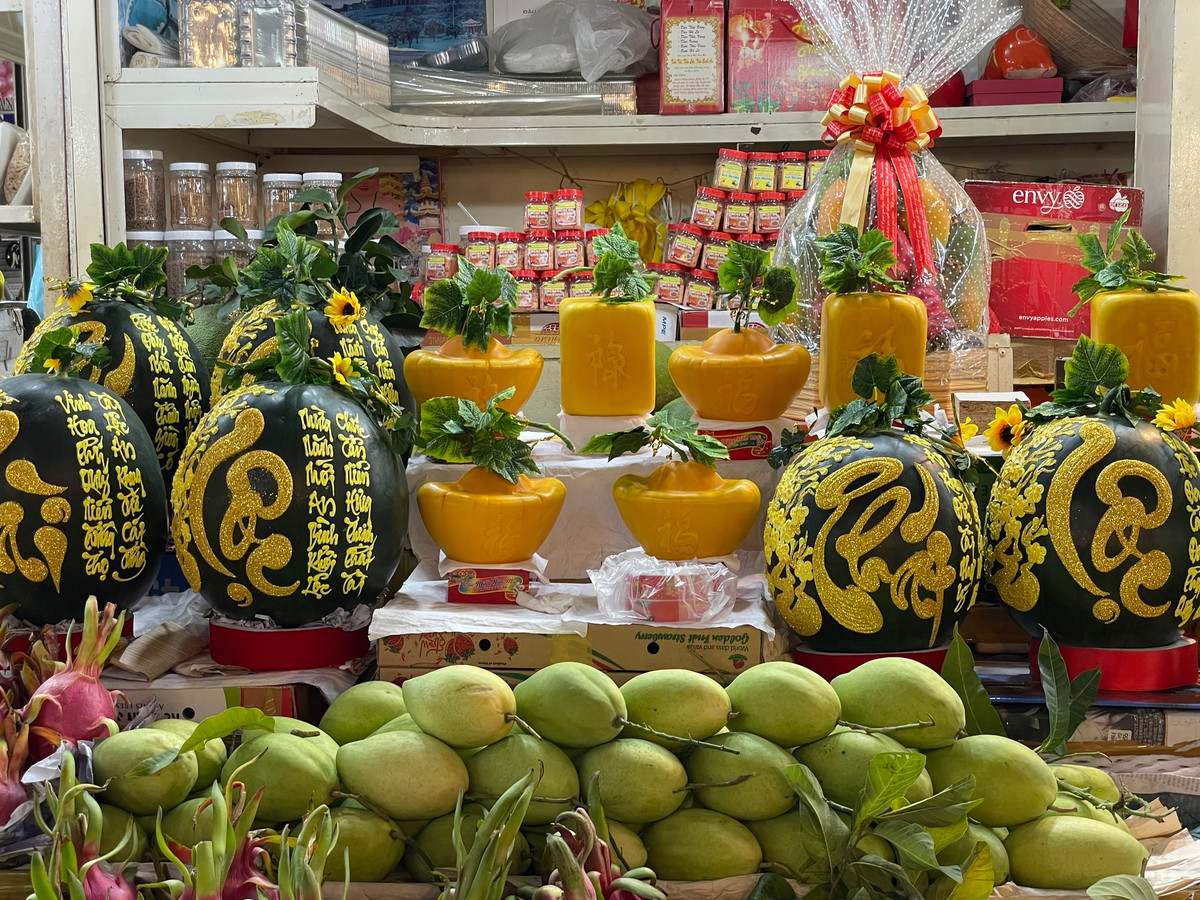 Dưa hấu khắc chữ thư pháp, dưa hình thỏi vàng có giá lên tới cả triệu đồng cũng được bày bán tại chợ chờ khách mua.