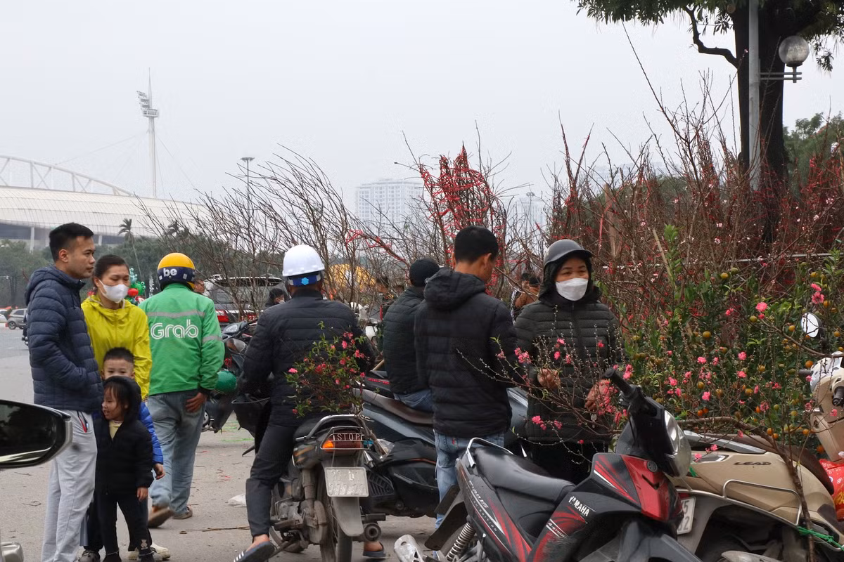 Người mua kẻ bán tấp nập, nhiều khách trả giá liên tục với mong muốn mua được cành đào đẹp giá phải chăng nhất.