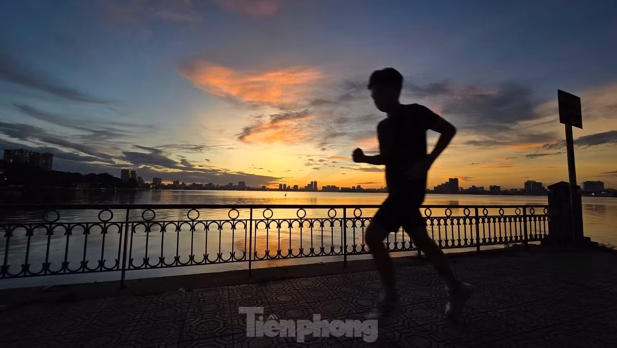 br/> Một người chạy tập thể dục dưới ánh vàng tuyệt đẹp của buổi hoàng hôn Hồ Tây.