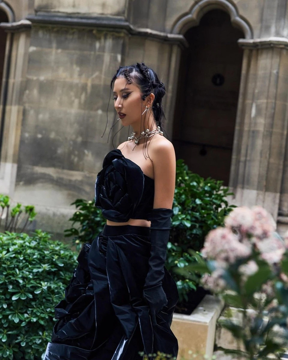 Diện set trang phục với thông điệp mỗi người phụ nữ là một loài hoa, Quỳnh Anh Shyn bổ sung đôi găng tay opera đồng màu với váy, nhanh chóng hưởng ứng xu hướng đeo găng tay thịnh hành trong mùa mốt đầu năm nay. Cô mang đến màu sắc gothic thông qua chiếc váy đen, layout makeup tối và phụ kiện kim loại gai góc. Với outfit này, Quỳnh Anh Shyn thành công xây dựng hình tượng bông hồng gai, thu hút sự chú ý của giới mộ điệu trong dịp 8/3. Ảnh: @quynhanhshyn_.