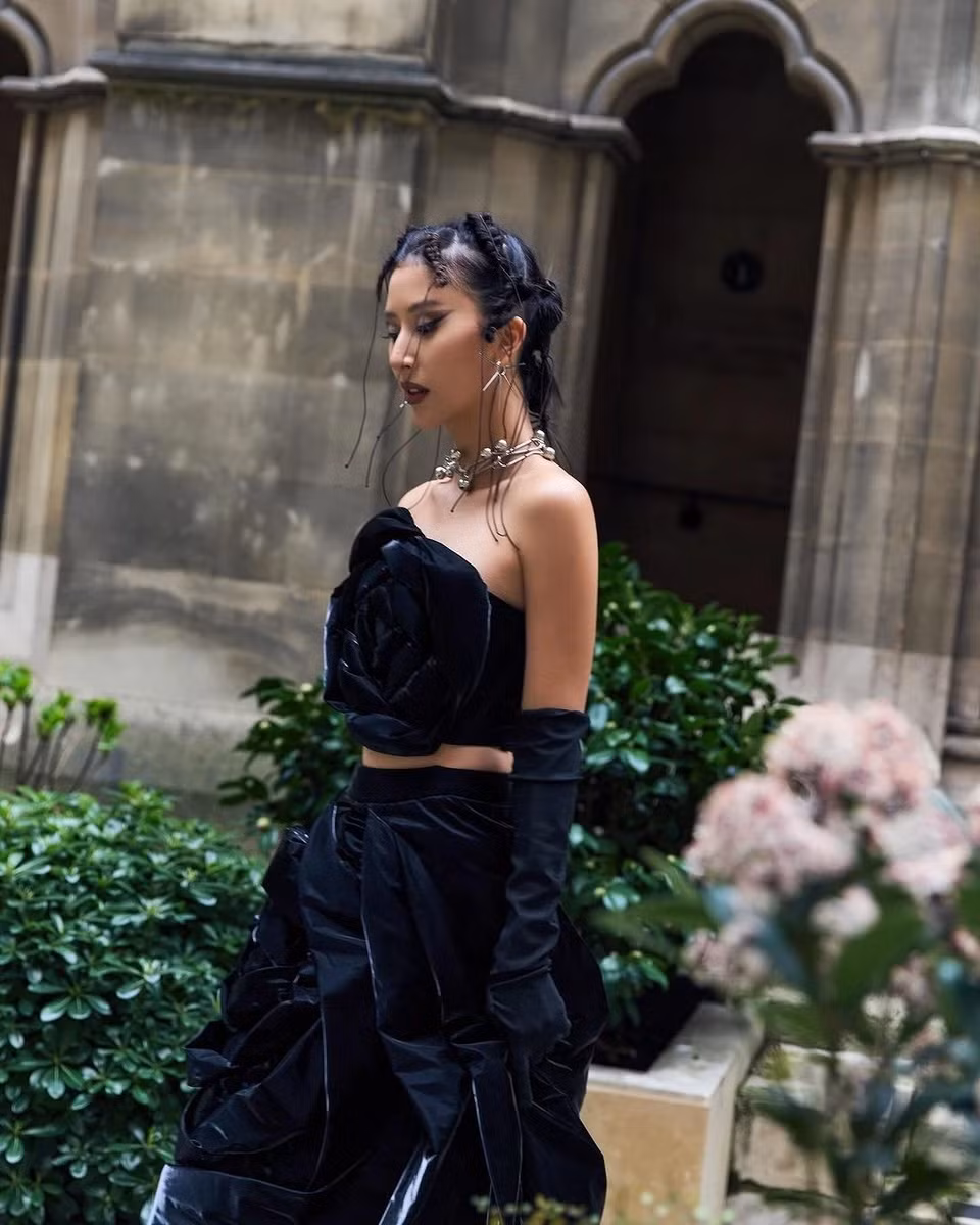 Diện set trang phục với thông điệp mỗi người phụ nữ là một loài hoa, Quỳnh Anh Shyn bổ sung đôi găng tay opera đồng màu với váy, nhanh chóng hưởng ứng xu hướng đeo găng tay thịnh hành trong mùa mốt đầu năm nay. Cô mang đến màu sắc gothic thông qua chiếc váy đen, layout makeup tối và phụ kiện kim loại gai góc. Với outfit này, Quỳnh Anh Shyn thành công xây dựng hình tượng bông hồng gai, thu hút sự chú ý của giới mộ điệu trong dịp 8/3. Ảnh: @quynhanhshyn_.