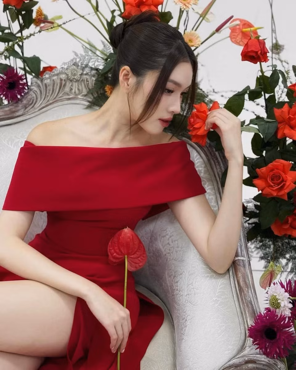 Thanh Thanh Huyền ghi điểm với chiếc đầm đỏ trễ vai đơn giản, thanh lịch. Giống với Thảo Nhi Lê, Thanh Thanh Huyền nhanh chóng ứng dụng sắc đỏ trên trang phục, hưởng ứng trào lưu thời trang này. Điểm nhấn của thiết kế là chi tiết xẻ cao, giúp người mặc khoe khéo đôi chân dài. Cô cũng khéo léo thực hiện kiểu tóc búi xòe quạt, phô diễn cổ cao, xương quai xanh gợi cảm khi mặc chiếc váy này. Những bông hoa đồng màu với đầm trở thành phụ kiện cho outfit, góp phần thể hiện tinh thần Quốc tế Phụ nữ. Ảnh: @mcthanhthanhhuyen.