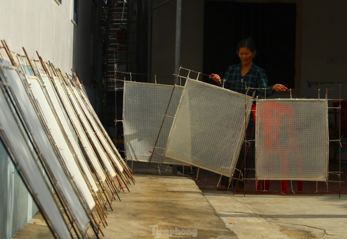 Sau khi những khuôn giấy được tráng một lớp nước mỏng tanh, bà Hải mang ra nắng phơi khô.