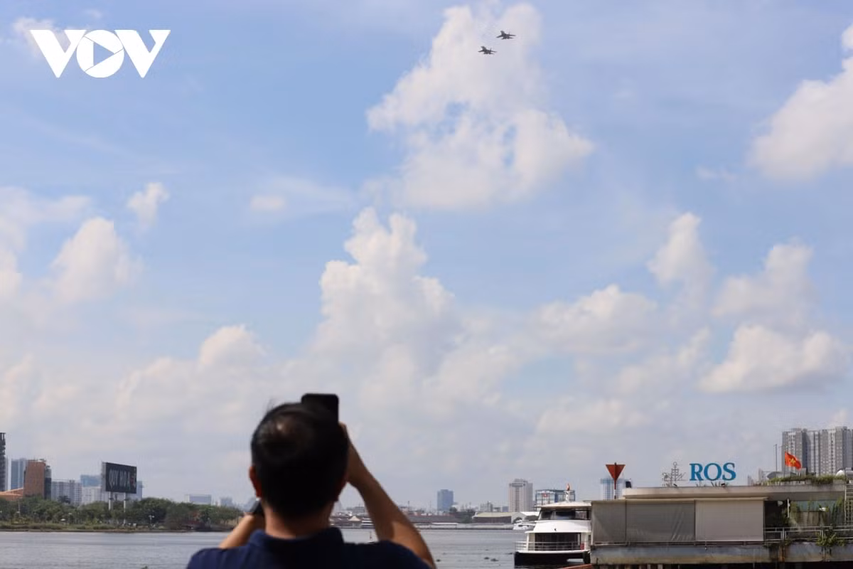Nhiều người cầm điện thoại ghi lại những hình ảnh ấn tượng về màn trình diễn máy bay ở bến Bạch Đằng