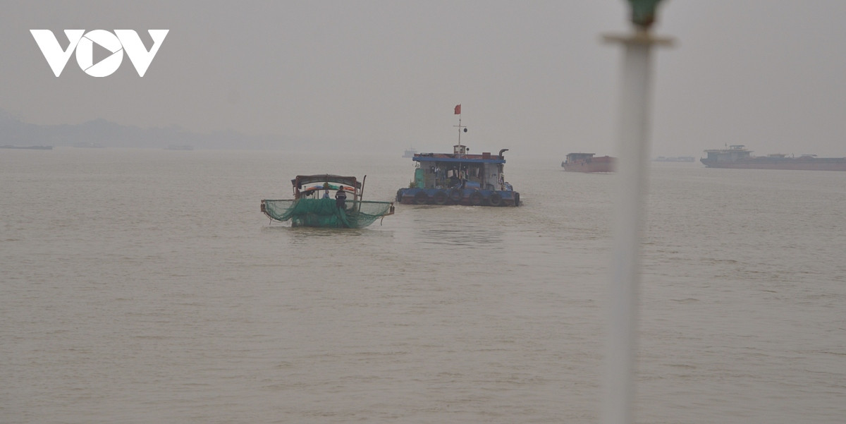 Một khúc sông rộng, nơi hiện diện cả sà lan và thuyền đánh cá. Đường trung tuyến giữa sông là ranh giới giữa tỉnh Hưng Yên và thành phố Hà Nội.