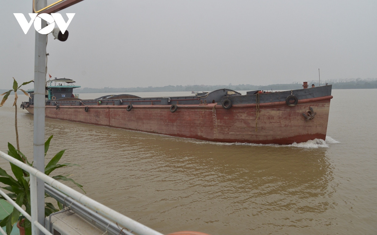 Tuyến sông Hồng này khá tấp nập, ngoài du thuyền và thuyền chài, còn có nhiều tàu vận tải. Trong ảnh là một sà lan của Phú Thọ đi qua đây.