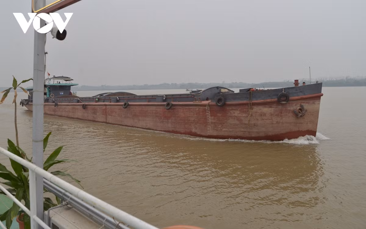 Tuyến sông Hồng này khá tấp nập, ngoài du thuyền và thuyền chài, còn có nhiều tàu vận tải. Trong ảnh là một sà lan của Phú Thọ đi qua đây.