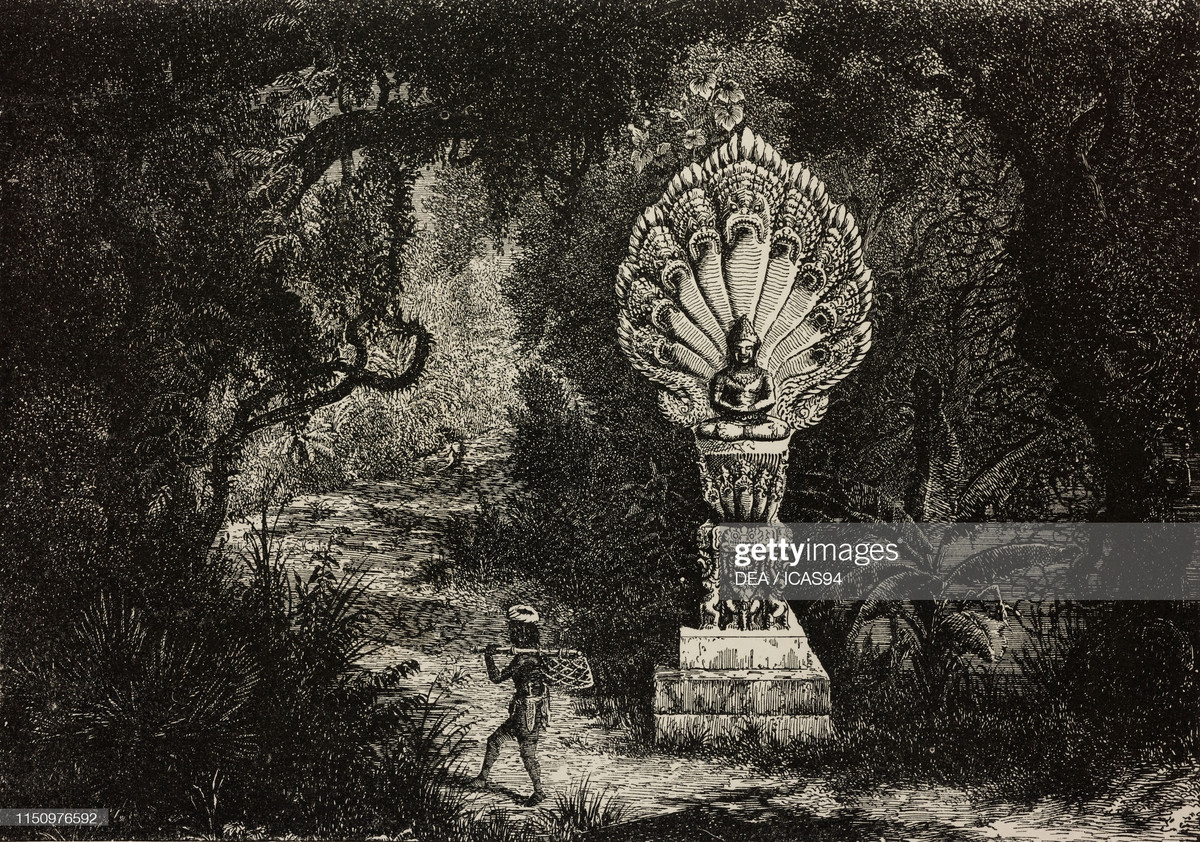 Một người địa phương đi qua bức tượng thần, là một phần của lan can cây cầu đổ ở Ta On.