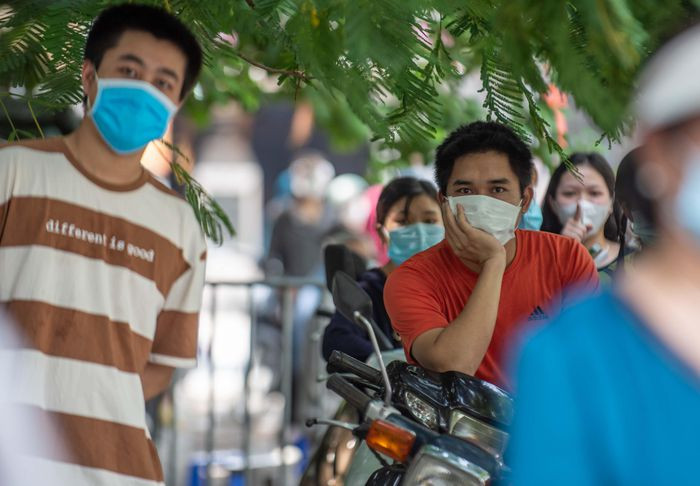 Anh Lê Thành Độ (áo da cam) được mẹ đăng ký với phường để tiêm vaccine. Theo lịch, chiều 9/9 đến lượt anh. "Tôi đứng đợi được gần một giờ rồi mà người tiêm buổi sáng vẫn chưa xong. Tôi cũng chưa được phát phiếu thứ tự", anh Độ nói. Anh cho biết mình là lái xe tự do, việc được tiêm vaccine là rất cần thiết để được đi làm.