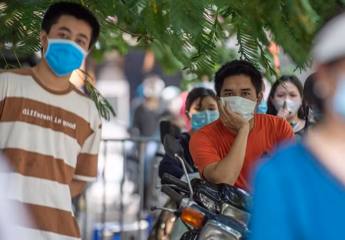 Anh Lê Thành Độ (áo da cam) được mẹ đăng ký với phường để tiêm vaccine. Theo lịch, chiều 9/9 đến lượt anh. "Tôi đứng đợi được gần một giờ rồi mà người tiêm buổi sáng vẫn chưa xong. Tôi cũng chưa được phát phiếu thứ tự", anh Độ nói. Anh cho biết mình là lái xe tự do, việc được tiêm vaccine là rất cần thiết để được đi làm.