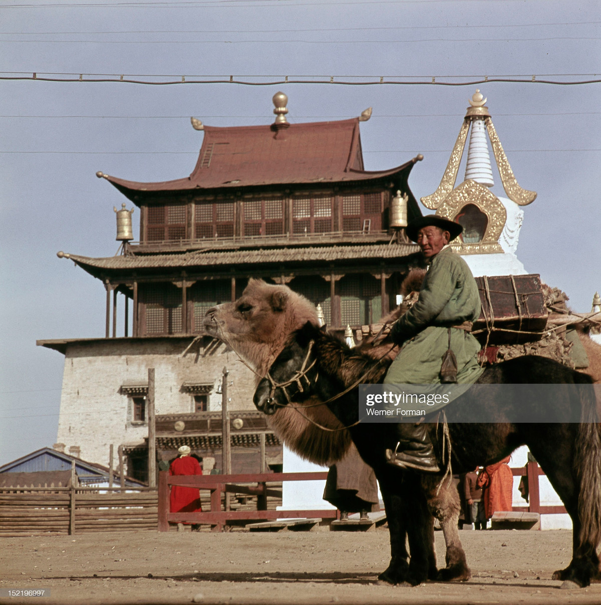 Người đàn ông Mông Cổ cưỡi ngựa, bên cạnh là con lạc đà chở đồ đạc, bên ngoài tu viện Gandantegchinlen.
