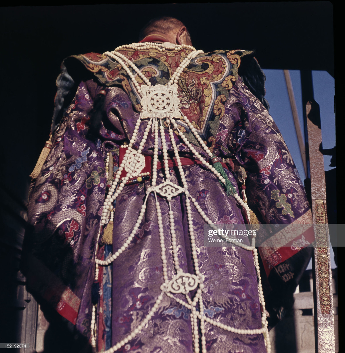 Vị thầy tế mặc trang phục lộng lẫy với áo choàng thổ cẩm gắn nhiều đồ trang sức.