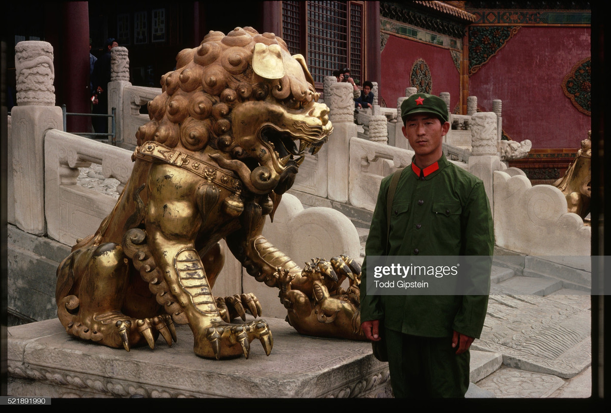 Quân nhân trẻ chụp hình lưu niệm bên tượng sư tử ở Bảo tàng Cố cung, Bắc Kinh.