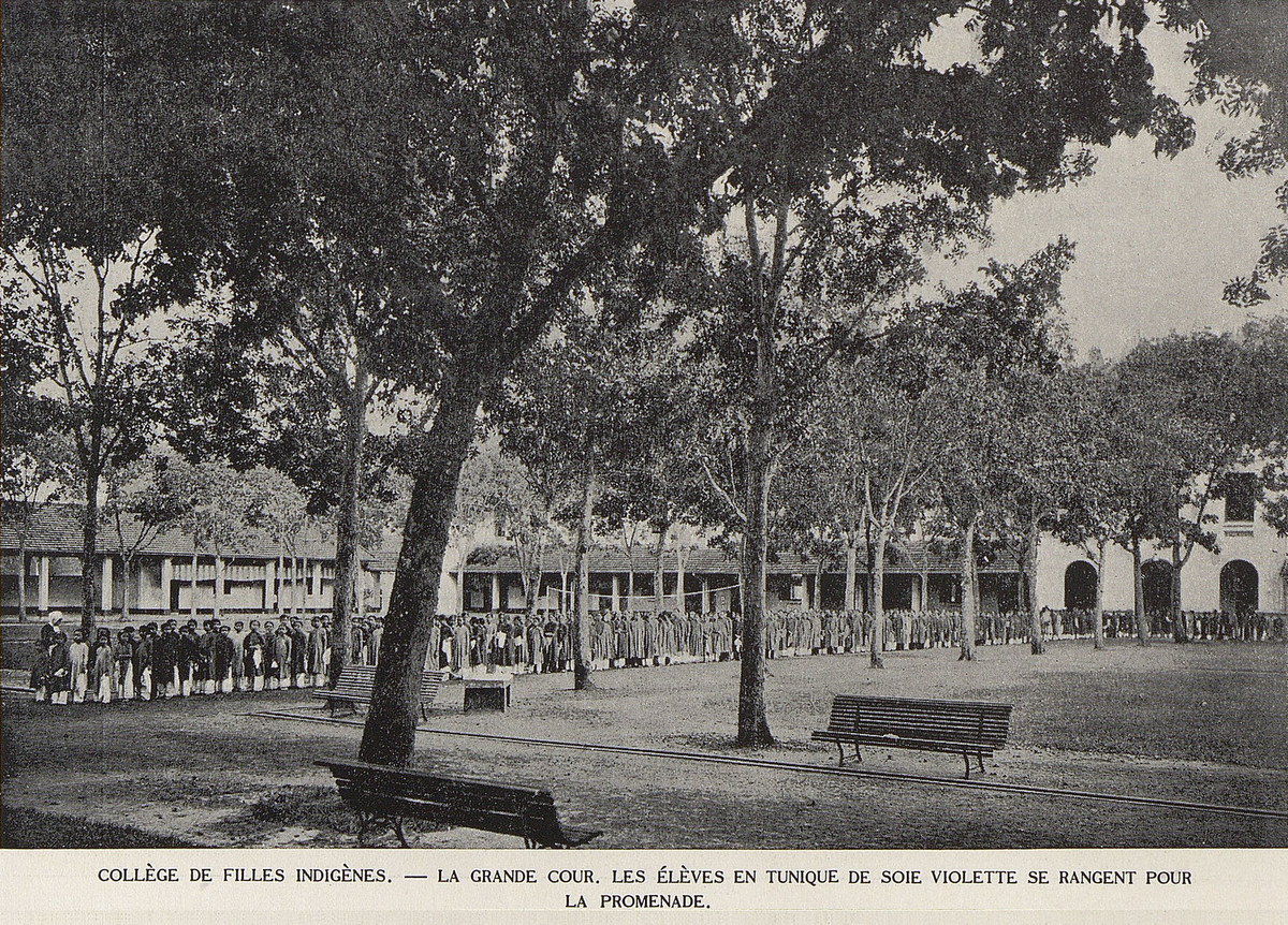 Các nữ sinh mặc áo dài lụa tím xếp hàng đi dạo trên sân trường Nữ trung học Bản xứ.