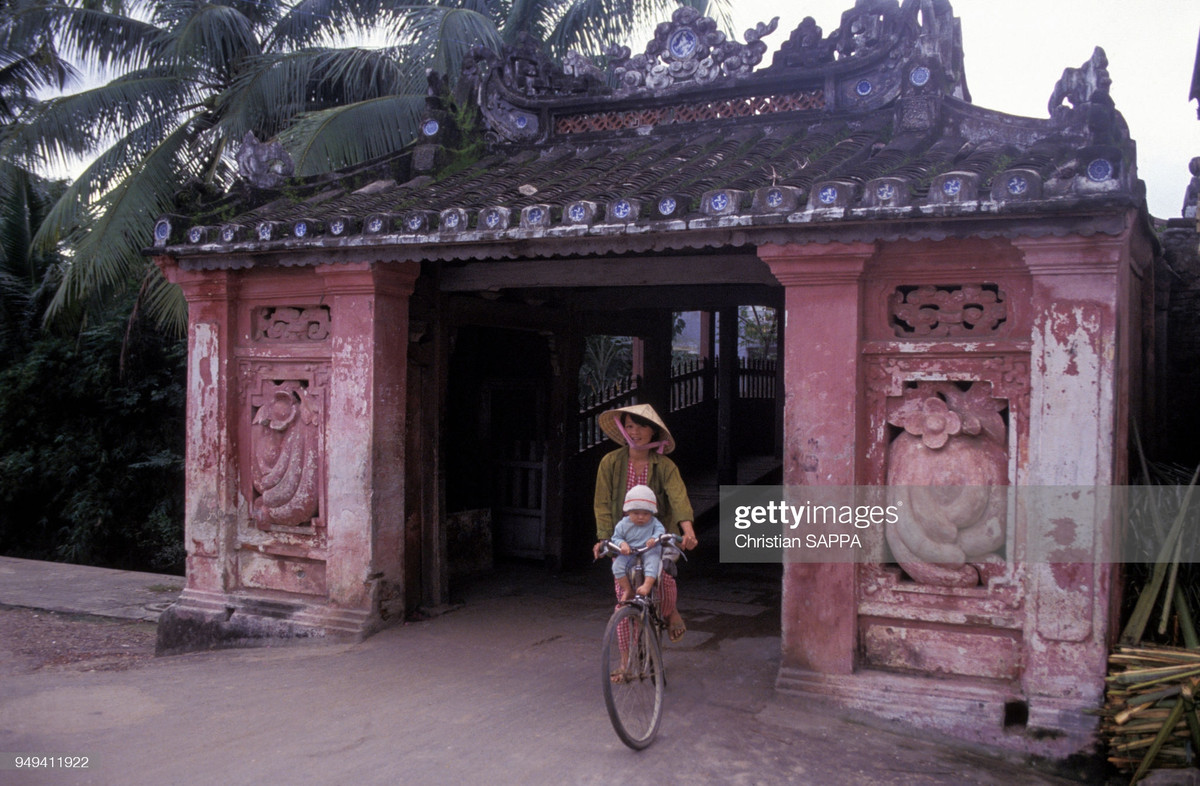 Hai mẹ con đạp xe qua Chùa Cầu Hội An.