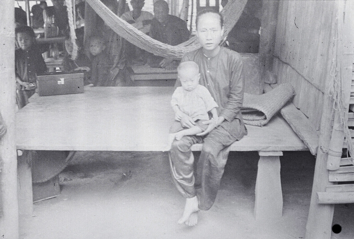 Hai mẹ con ngồi trên tấm phản.