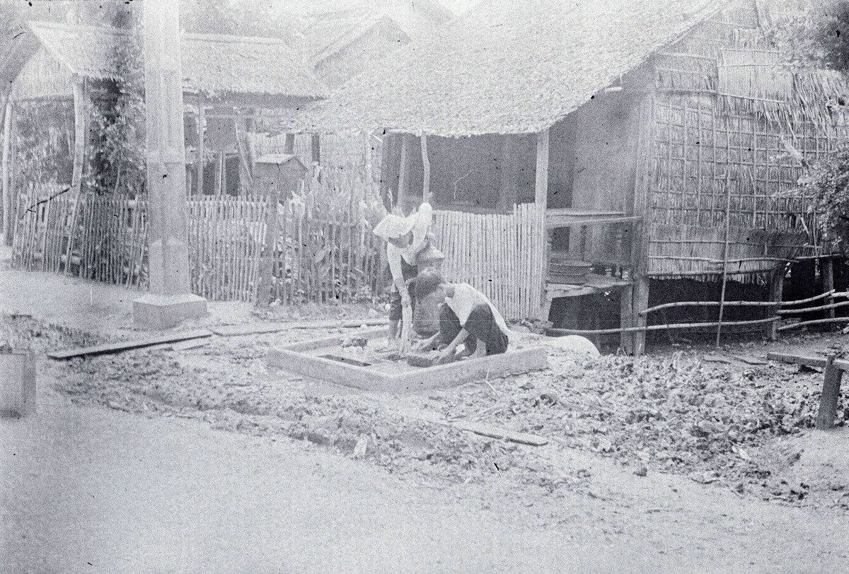 Hai người làng lui cui bên vòi nước công cộng ở làng Bình Mỹ.