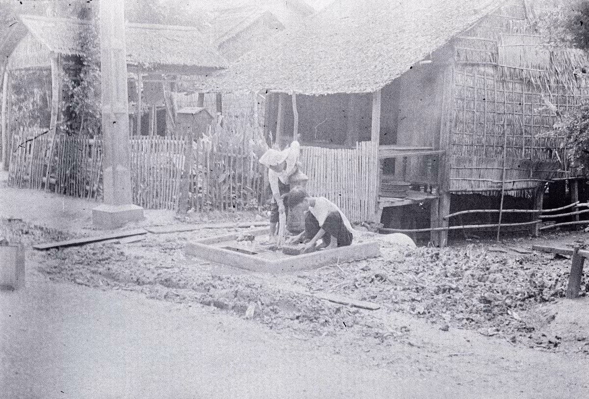 Hai người làng lui cui bên vòi nước công cộng ở làng Bình Mỹ.