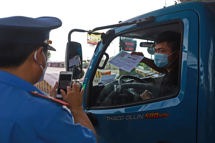 Tại làn kiểm soát xe luồng xanh vận tải, 2 thanh tra giao thông quét mã QR từng phương tiện và kiểm tra hành trình của tài xế. Giấy vận tải luồng xanh của xe này không hợp lệ. Nam tài xế sau đó cho biết giấy trên kính xe đã hết hạn và người này lấy mã QR mới từ trong xe ra. Mất gần 5 phút, ôtô này mới có thể di chuyển.