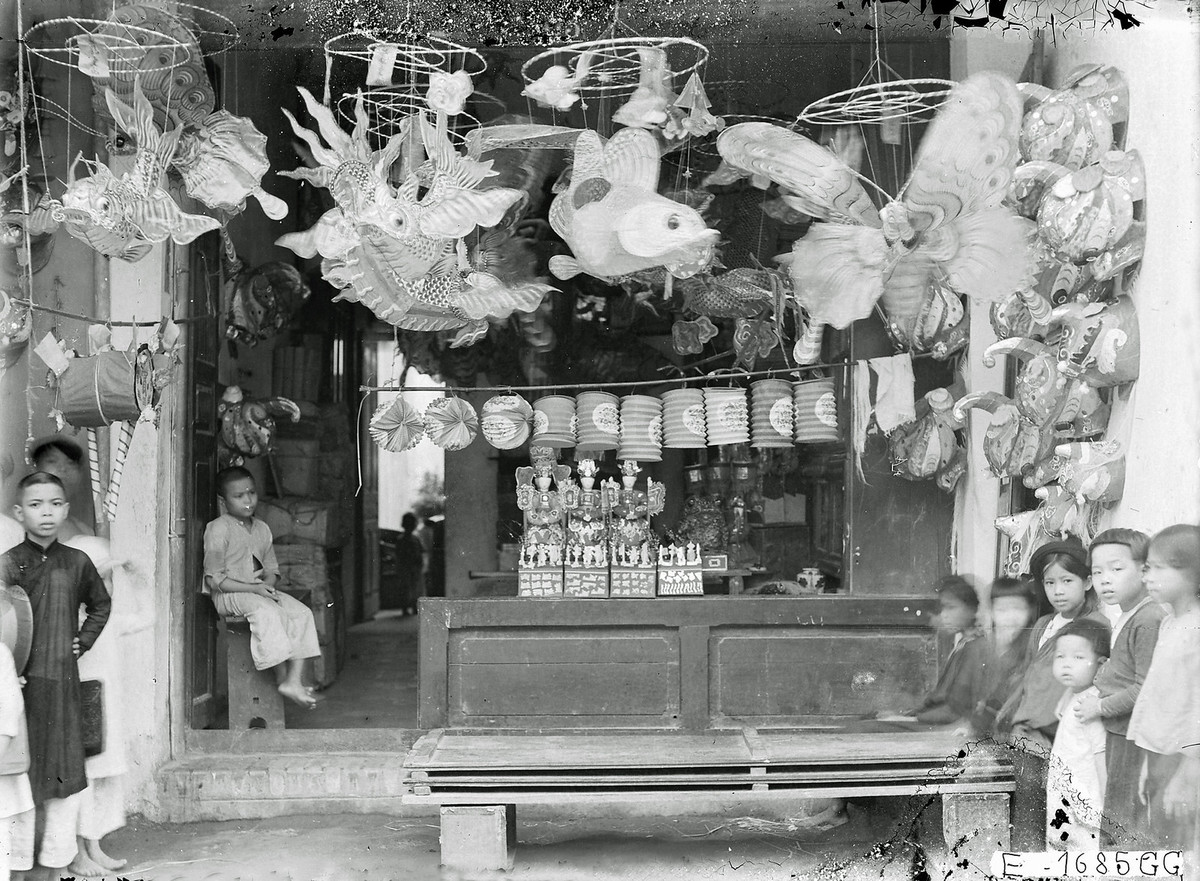 Những đứa trẻ đứng hai bên cửa hàng đèn lồng và đồ chơi Trung thu ở phố Hàng Gai.